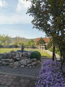 a garden with a stone wall and purple flowers at Casa Laura in Rijeka