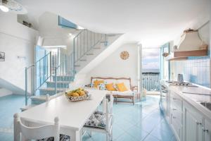 a kitchen with a staircase and a table with a bowl of fruit at Casa Athina in Procida