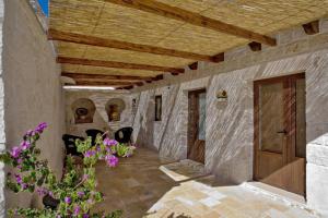 un pasillo exterior de una casa con techo de madera en B&B Salita Delle Pere, en Alberobello