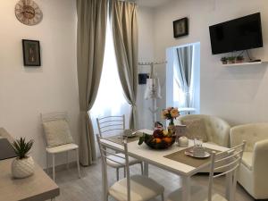 un soggiorno con tavolo e sedie bianchi di Protea House ad Alghero