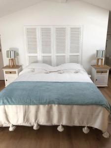 ein Schlafzimmer mit einem großen Bett mit zwei Nachttischen in der Unterkunft Bellevue in Saintes-Maries-de-la-Mer