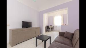 a living room with a couch and a flat screen tv at Spacious modern and cozy apartment in Trapani