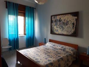 ディアマンテにあるDiamante sole mareのベッドルーム1室(青いカーテンと絵画付)