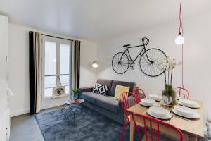 uma sala de estar com uma mesa e uma bicicleta pendurada na parede em Charming House for 6 people - Louvre & Opera em Paris