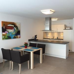 cocina con mesa, sillas y barra en Starenweg Appartements, en Langenargen
