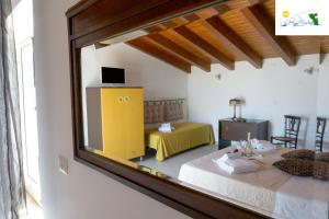 a mirror reflection of a room with a bed and a table at Marìsicilia in Porto Empedocle