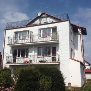 Una casa blanca con balcones en un lateral. en Pokoje Gościnne en Mielno
