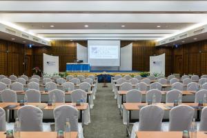 a conference room with tables and chairs and a screen at Deevana Plaza Krabi Aonang - SHA Extra Plus in Ao Nang Beach