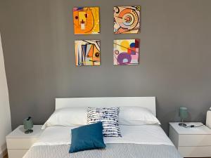 een slaapkamer met vier foto's aan de muur boven een bed bij la terrazza sul porto in Napels
