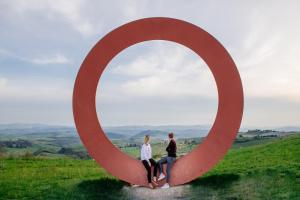 Un uomo e una donna seduti dentro una grande scultura di Villa Aia Vecchia a Bibbona