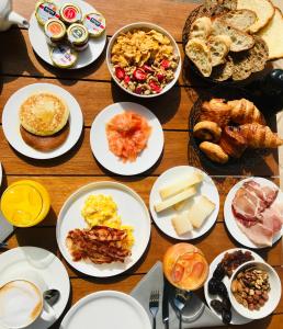 a table with plates of breakfast food on it at Hotel Centre Nautique in Bonifacio