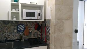 a kitchen with a sink and a microwave at Casa Vacanze Scicli Centro in Scicli