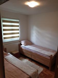 Cette chambre comprend 2 lits et une fenêtre. dans l'établissement Vacation home Djogic, à Ilidža