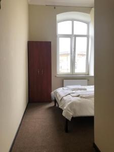 a bedroom with a bed and a window at El Mundo Apartments in Lviv
