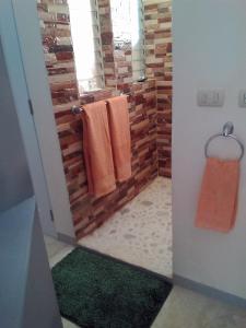 a bathroom with orange towels and green rugs at Domaine Vista Linda La casita del Loma Vista Mar in Río San Juan