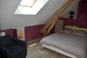 a bedroom with a bed and a chair at Les Gîtes du Villajou in Lachapelle-Auzac