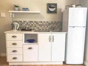 Una cocina con un refrigerador blanco y un fregadero. en Lavender Suite, en Ciudad del Cabo