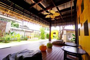 a porch with two chairs and a ceiling fan at Baan Ma Feung GuestHouse in Kanchanaburi