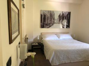 um quarto com uma cama e uma fotografia na parede em B&B Casale Coreallo Spotorno em Spotorno