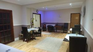 a dining room with tables and chairs and purple walls at Arman Lodge House in Peterborough