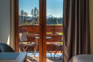 a balcony with a view of a table and chairs at PRZY TERMACH apartamenty, pokoje - podgrzewany basen, hydromasaż i tylko 70m Termy in Szaflary