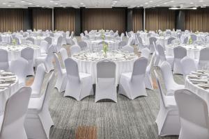 a banquet hall with white tables and chairs at Metropolo by Golden Tulip Krakow in Krakow