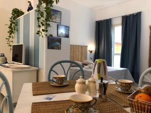 a dining room with a table and a room with a bed at Appartamenti Milù - Milù Holidays La Maddalena in La Maddalena
