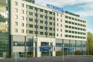 a large white building with a sign on it at Metropolo by Golden Tulip Krakow in Krakow