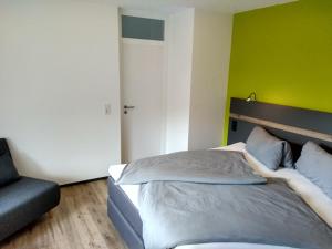 Apartment Haus Sembachtal في Winterstein: غرفة نوم بسرير وكرسي