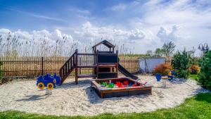 a playground with a slide in the sand at Perla Mare Apartamenty in Krynica Morska