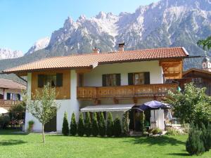 a large house with mountains in the background at Ferienwohnung 1 Kofler in Mittenwald