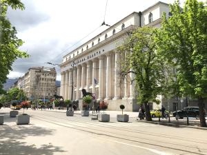 un gran edificio en una calle con árboles delante en Courthouse Apartments Slavi, en Sofía