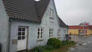 Casa blanca con techo de baldosa en una calle en 665 Løkkensvej, en Løkken