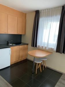 eine kleine Küche mit einem Tisch und einem Waschbecken in der Unterkunft Hotel Arcato in De Haan