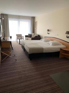 een hotelkamer met een bed en een woonkamer bij Hotel Arcato in De Haan