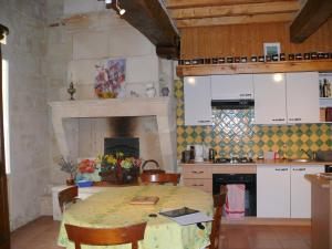 a kitchen with a table and a kitchen with a fireplace at Les Oiseaux in Saint-Émilion