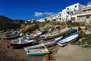 a group of boats sitting on the sand near a building at Apartamento la Isletilla in Almería