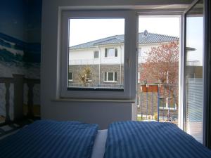 ein Schlafzimmer mit einem Bett und einem großen Fenster in der Unterkunft Haus Steinbach in Kellenhusen