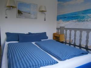 a bedroom with two beds with blue pillows at Haus Steinbach in Kellenhusen