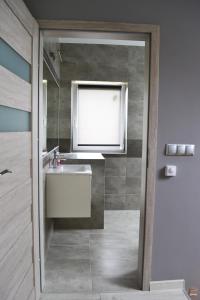 a bathroom with a sink and a mirror at LENIÓWKA in Ponikiew +4 photos