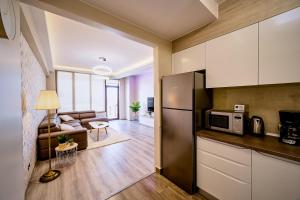 uma cozinha com um frigorífico e uma sala de estar em Penthouse Chic by Landev em Braşov