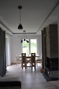 a living room with a dining room table and chairs at LENIÓWKA in Ponikiew