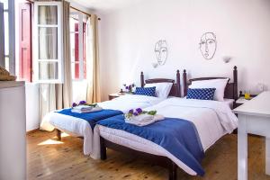 a bedroom with two beds with blue and white sheets at Talos in Chania Town