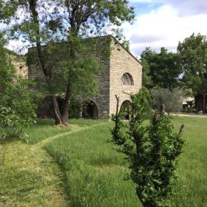 an old stone building in a field with trees at Maison de vacances sud Ardèche in Berrias Et Casteljau