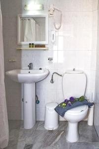 a white bathroom with a toilet and a sink at Talos in Chania Town