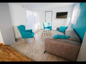 - un salon avec un canapé et deux fauteuils bleus dans l'établissement charmante maison lumineuse et confortable, à Le Poinçonnet