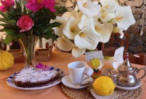 a table with a vase of flowers and a cake at B&B Casale Coreallo Spotorno in Spotorno +28 photos
