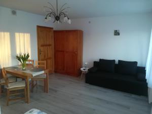 a living room with a black couch and a table at Morska Fala in Karwia