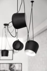 a black chair and a light hanging from a ceiling at Sopot Hills - White Apartment in Sopot