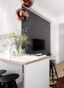 a kitchen with a white counter with a vase of flowers at Sopot Hills - White Apartment in Sopot